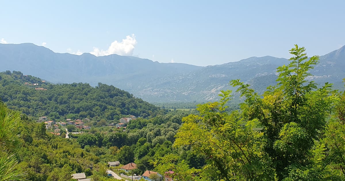 Wooded valley with village houses and mountains in Montenegro